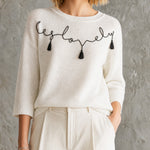 ElevenOra Chic Off-White Round Neck Black Handwritten Letter Embroidery Tassel Detail Three-Quarter Sleeve Loose-Fit Knit Sweater Top