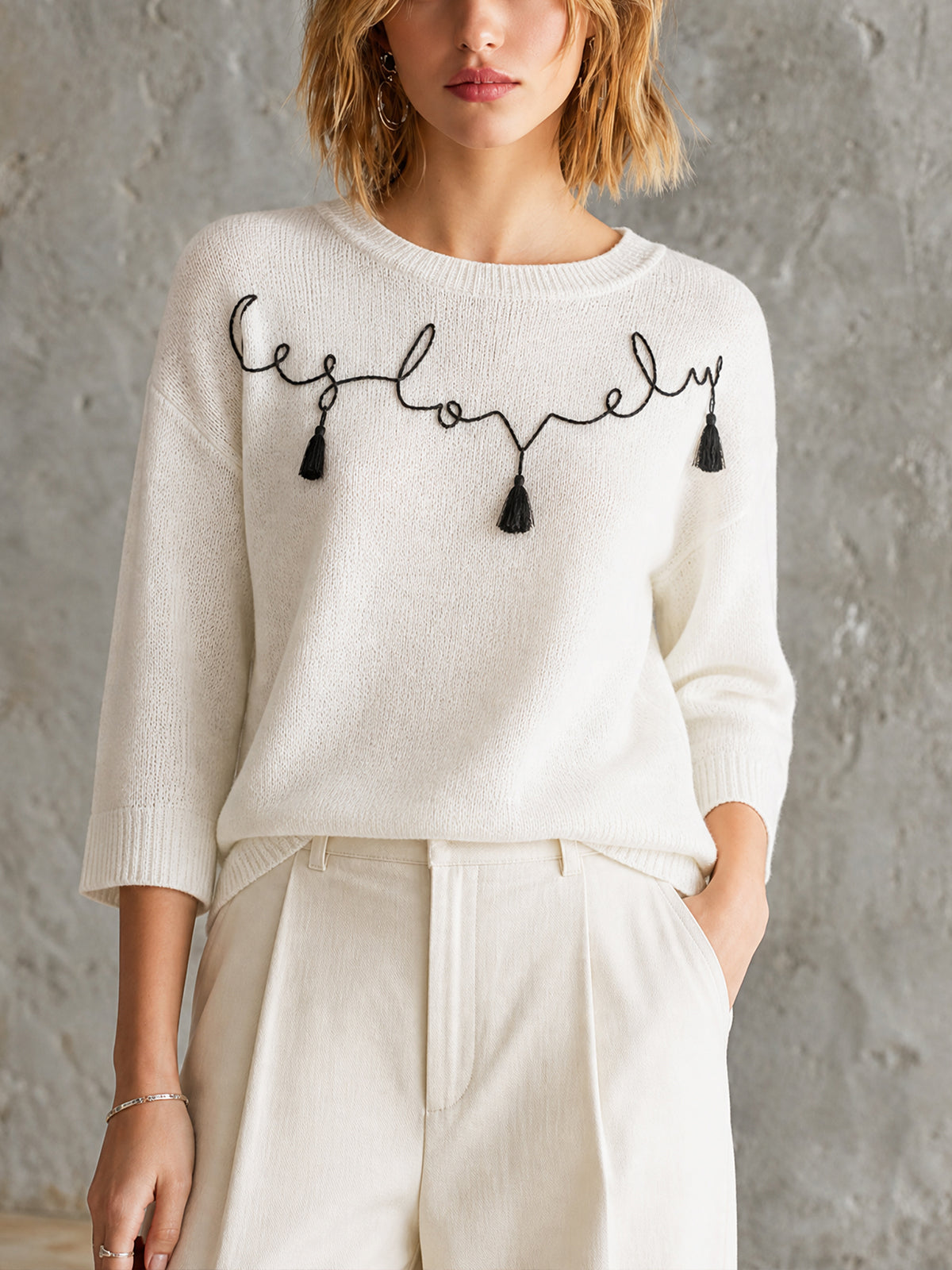 ElevenOra Chic Off-White Round Neck Black Handwritten Letter Embroidery Tassel Detail Three-Quarter Sleeve Loose-Fit Knit Sweater Top