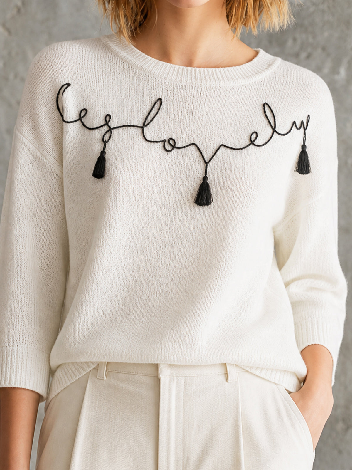 ElevenOra Chic Off-White Round Neck Black Handwritten Letter Embroidery Tassel Detail Three-Quarter Sleeve Loose-Fit Knit Sweater Top